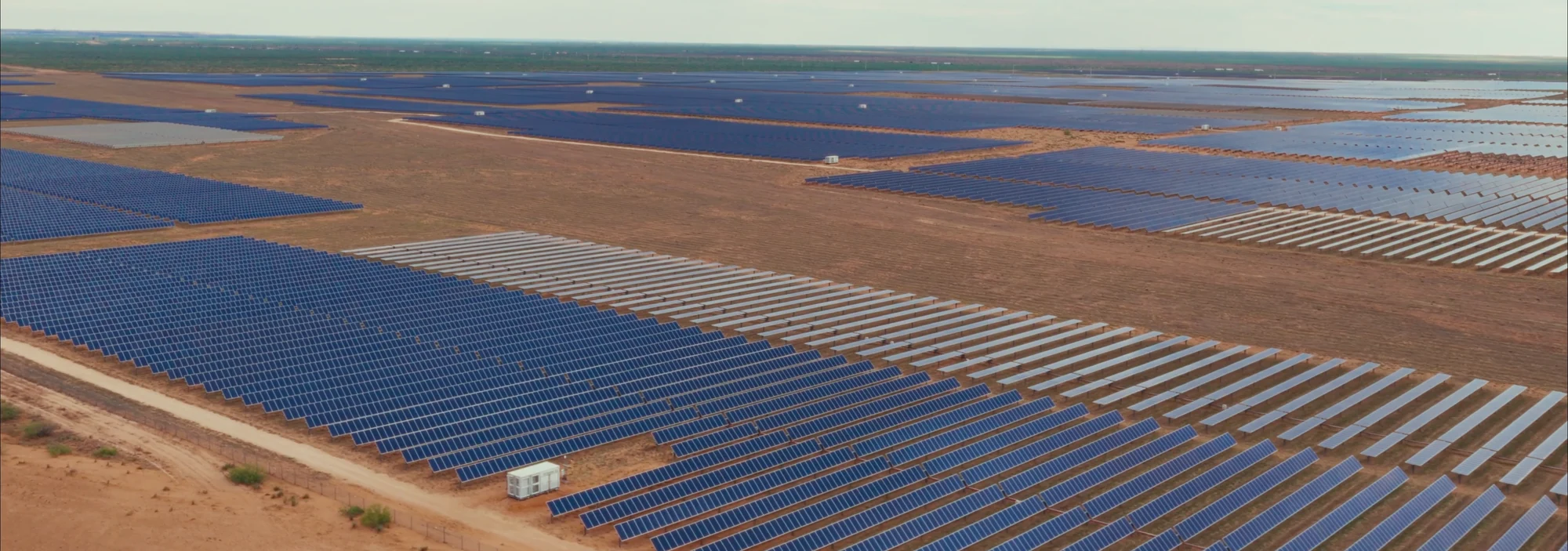 Rows of solar panels stretching across the open landscape at the Sangha facility.